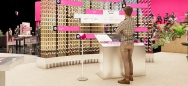 Visitor standing in front of a large modular installation with data visualizations and interactive screens.